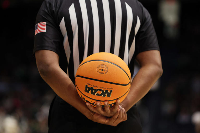 DAYTON, OHIO - MARCH 16: A referee holds the ball in the second half of the game between the Bryant University Bulldogs and the Wright State Raiders during the First Four game of the 2022 NCAA Men's Basketball Tournament at UD Arena on March 16, 2022 in Dayton, Ohio. (Photo by Andy Lyons/Getty Images)