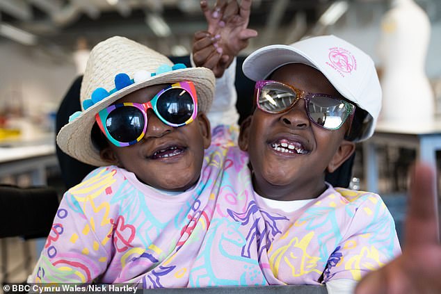 senegalese father who lives in cardiff with his conjoined twin girls, who share one pair of legs and several organs, says it's a 'huge privilege' to raise them after being told they wouldn't survive for more than a few days