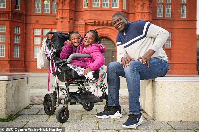 senegalese father who lives in cardiff with his conjoined twin girls, who share one pair of legs and several organs, says it's a 'huge privilege' to raise them after being told they wouldn't survive for more than a few days