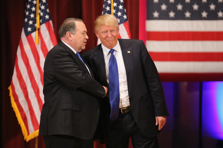 Republican presidential candidate Donald Trump (R) and rival candidate Mike Huckabee shake hands during the rally for veterans at Drake University on January 28, 2016 in Des Moines, Iowa. A kids' book released by Huckabee's publisher, EventBright Media, discusses Trump's first term in office and continues to garner attention.