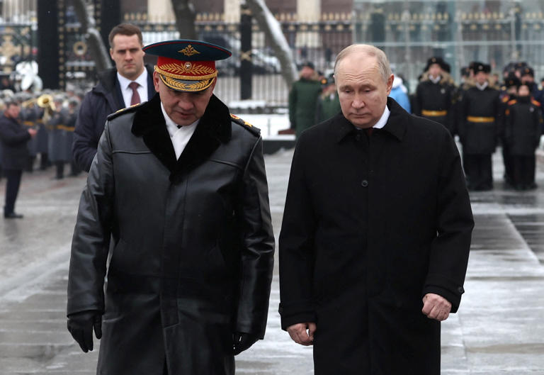 Russian President Vladimir Putin, right, and Defence Minister Sergey Shoigu speak after a wreath-laying ceremony marking Defender of the Fatherland Day at the Tomb of the Unknown Soldier by the Kremlin Wall in Moscow [File: Alexander Kazakov/Pool via Reuters]