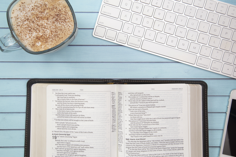 Overview of keyboard, coffee, phone, and bible