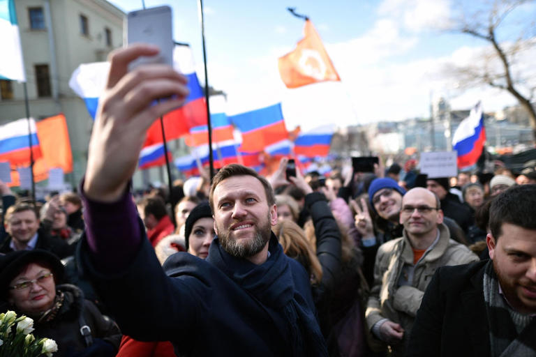 (FILES) Russian opposition leader and anti-corruption blogger Alexei Navalny takes a selfie picture as he attends a memorial march marking the one-year anniversary of the assassination of Russian politician Boris Nemtsov in central Moscow, on February 27, 2016. Nemtsov, a former deputy prime minister in the government of Boris Yeltsin, was gunned down shortly before midnight on February 27, 2015, while walking across a bridge a short distance from the Kremlin with his Ukrainian model girlfriend. AFP PHOTO / KIRILL KUDRYAVTSEV. Russian opposition leader Alexei Navalny died on February 16, 2024 at the Arctic prison colony where he was serving a 19-year-term, Russia's federal penitentiary service said in a statement. (Photo by Kirill KUDRYAVTSEV / AFP)