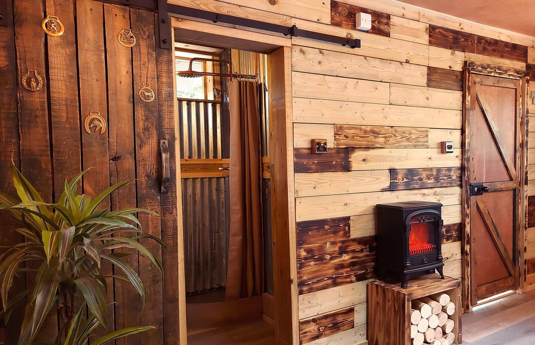 <p>Designed with a reclaimed and upcycled ethos in mind, the cabin is bursting with unusual details and handmade elements, from mismatched timber walls to sliding barn doors and even tree branch dividers. There’s a double bedroom, a sitting area with a log burner, a kitchen and a private bathroom with a composting, waterless toilet and shower.</p>