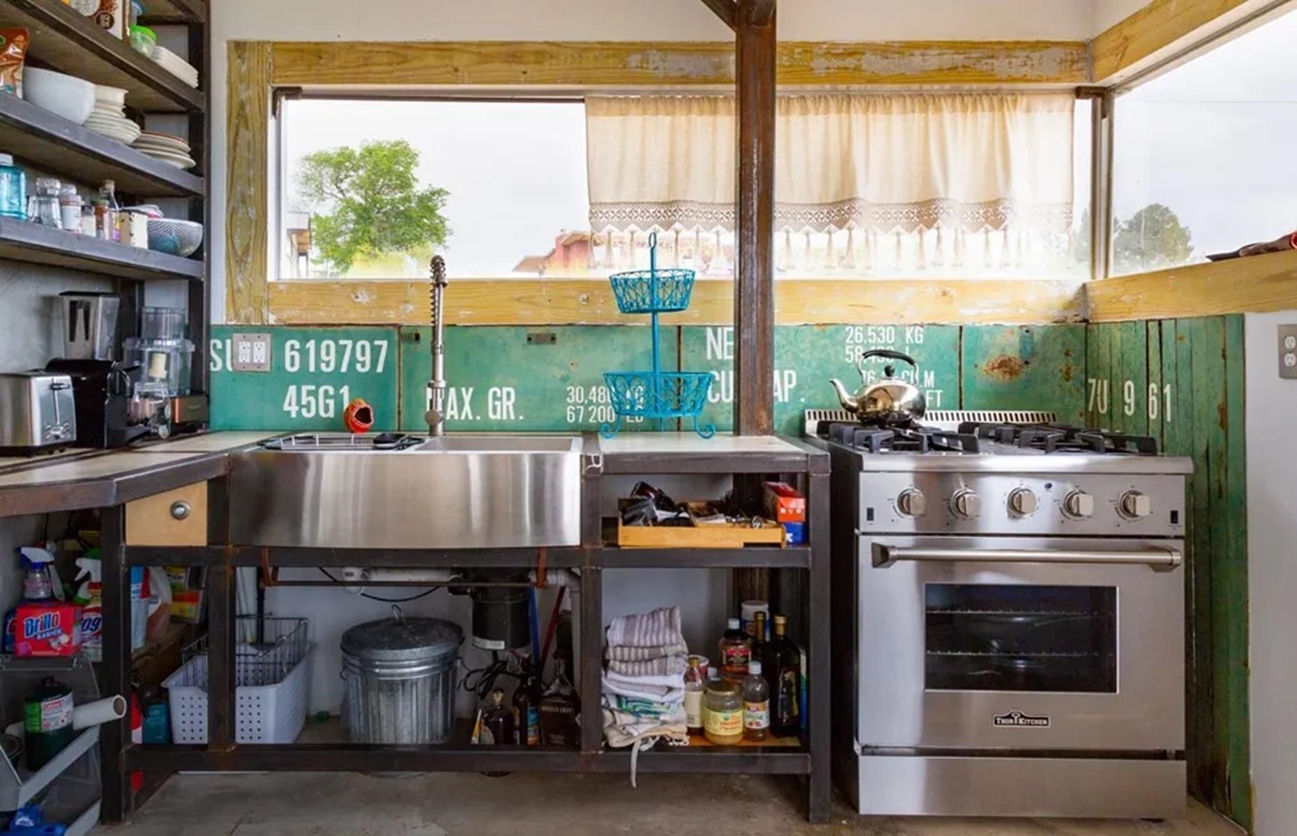 <p>Yet the handmade kitchen is perhaps the home's best asset. Rustic yet perfectly practical, it features a back wall decorated with the shipping container's original labeling. There are open storage shelves and wooden countertops. If you're in love, the property is for sale right now, via <a href="https://www.marfavistarealty.com/detail-1100-n-hermosa-street">Marfa Vista Real Estate</a>, for $525,000.</p>