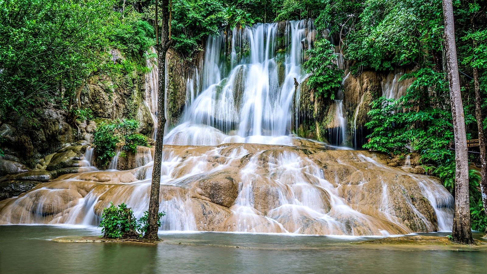 <p><span>Explore Sai Yok National Park, a haven of natural beauty and historical significance. The park’s landscape is dotted with stunning waterfalls, including the renowned Sai Yok Yai, which flows into the Kwai Noi River. The park’s rich biodiversity and historical sites, such as remnants of the Death Railway, offer a diverse experience.</span></p> <p><span>Choose adventures in river rafting, wildlife spotting, or a peaceful nature retreat; Sai Yok National Park caters to all. The park’s serene environment and history make it a unique and enriching destination in Kanchanaburi.</span></p> <p><b>Insider’s Tip: </b><span>Rent a raft house on the river for an overnight stay to fully immerse yourself in the natural beauty. </span></p> <p><b>When To Travel: </b><span>The dry season from November to February is ideal for visiting. </span></p> <p><b>How To Get There: </b><span>The park is about a 2-hour drive from Kanchanaburi town. Public transport is limited, so consider renting a car or booking a tour.</span></p>