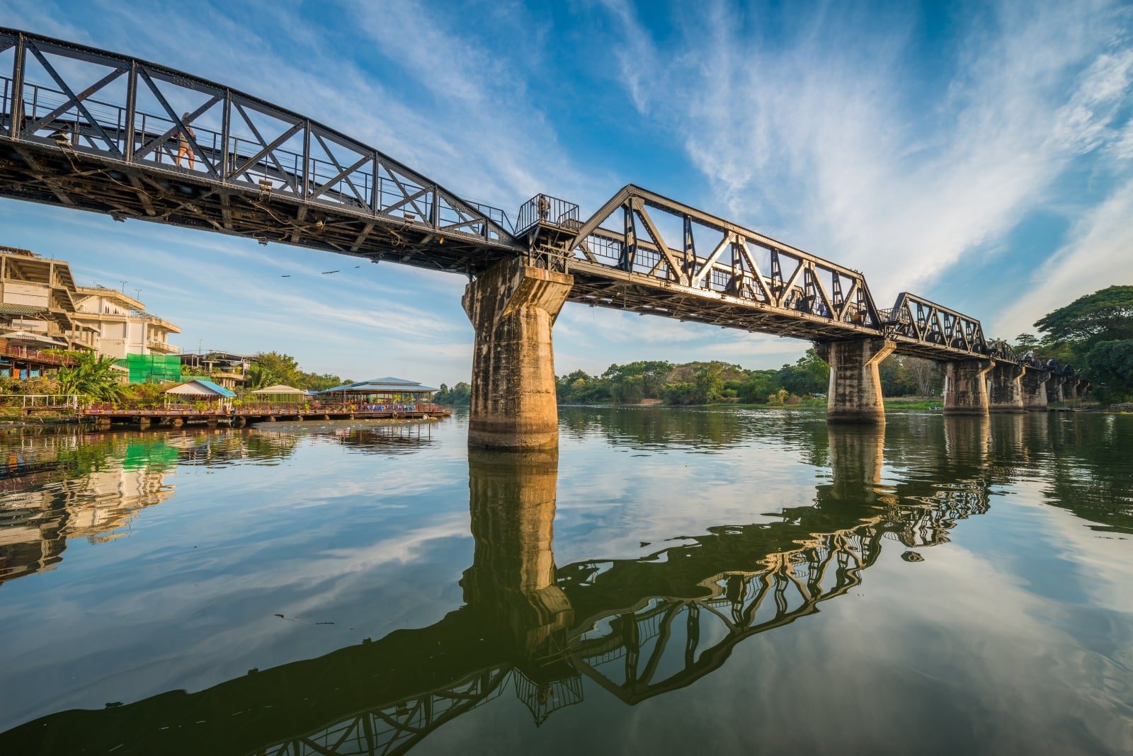 <p><span>As you approach the Bridge Over the River Kwai, you’re stepping into a chapter of World War II history. This bridge, a part of the infamous Death Railway, was built under harrowing conditions by prisoners of war. Today, it is a poignant reminder of the resilience and suffering of those who built it.</span></p> <p><span>The structure, set against the picturesque River Kwai, offers a solemn yet beautiful scene. Nearby museums enrich your understanding, providing historical context to this iconic landmark. Walking across this bridge, you’re walking through history, each step a tribute to the past.</span></p> <p><b>Insider’s Tip: </b>To avoid the heat and crowds, early mornings or late evenings are ideal for visiting<span>. </span></p> <p><b>When To Travel: </b><span>The cooler months from November to February are the best time to visit. </span></p> <p><b>How To Get There: </b><span>Kanchanaburi is accessible by bus or train from Bangkok, with the journey taking approximately 2-3 hours.</span></p>