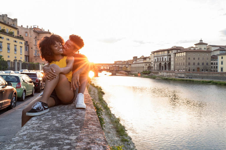 couple sitting near river in Florence, Italy