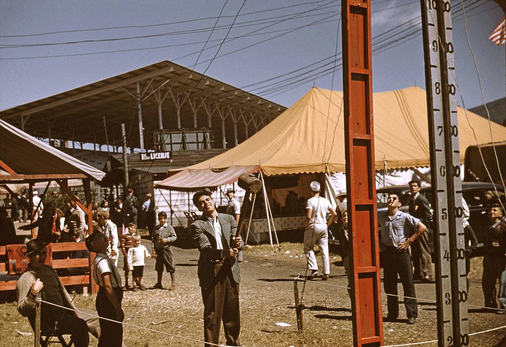 <p>Unfortunately, most state fairs ended up being closed during World War II in order to focus on the war effort. However, at the end of the decade, they experienced an explosion in popularity, bringing them back to the forefront of the entertainment industry. </p> <p>Featured here is a fair attendee in Vermont about to try his hand at ringing the bell with the hammer. It's safe to assume he's trying to impress someone that's watching on the sideline. </p>
