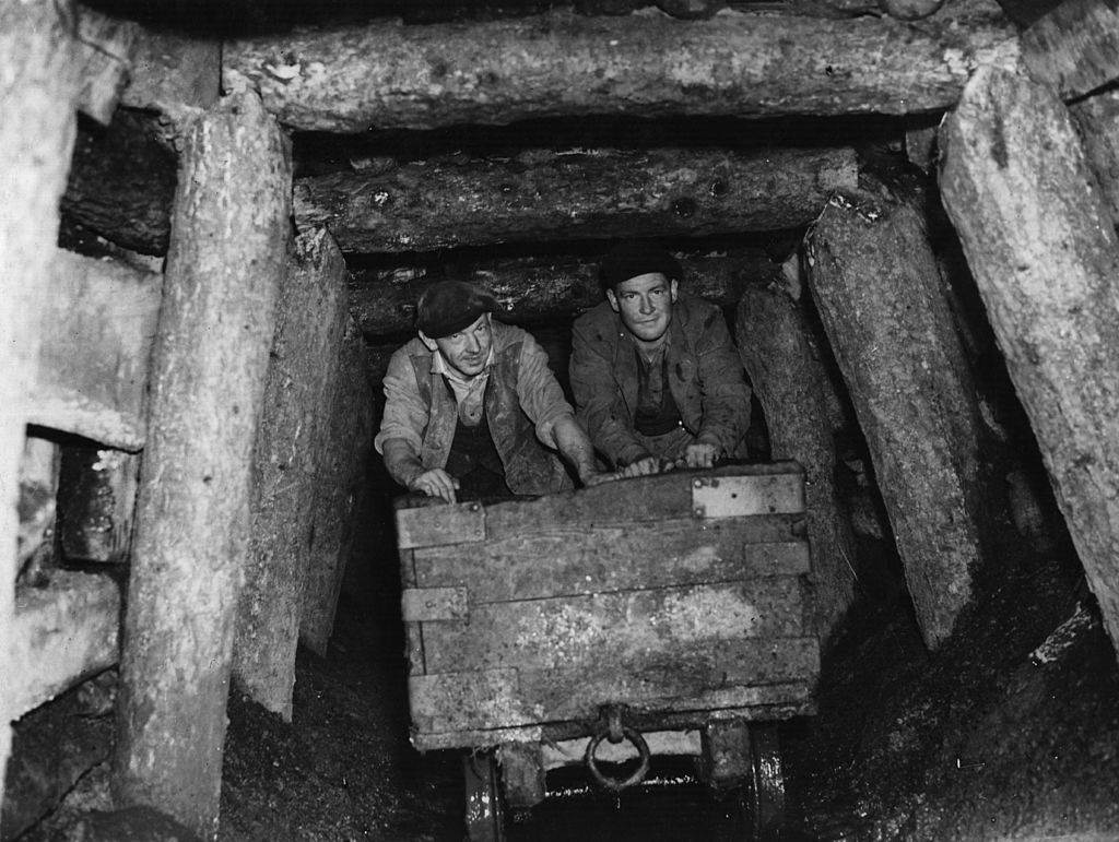 <p>Even during the 1940s, some people were still mining the earth the same way that it had been done for hundreds of years. These workers did their jobs in extremely hostile and hazardous conditions, leading to many of them not living very long lives. </p> <p>Here, two miners are wheeling a cart out from a mine shaft that's held together with nothing but pieces of wood. This picture is estimated to have been taken back in 1941. </p>