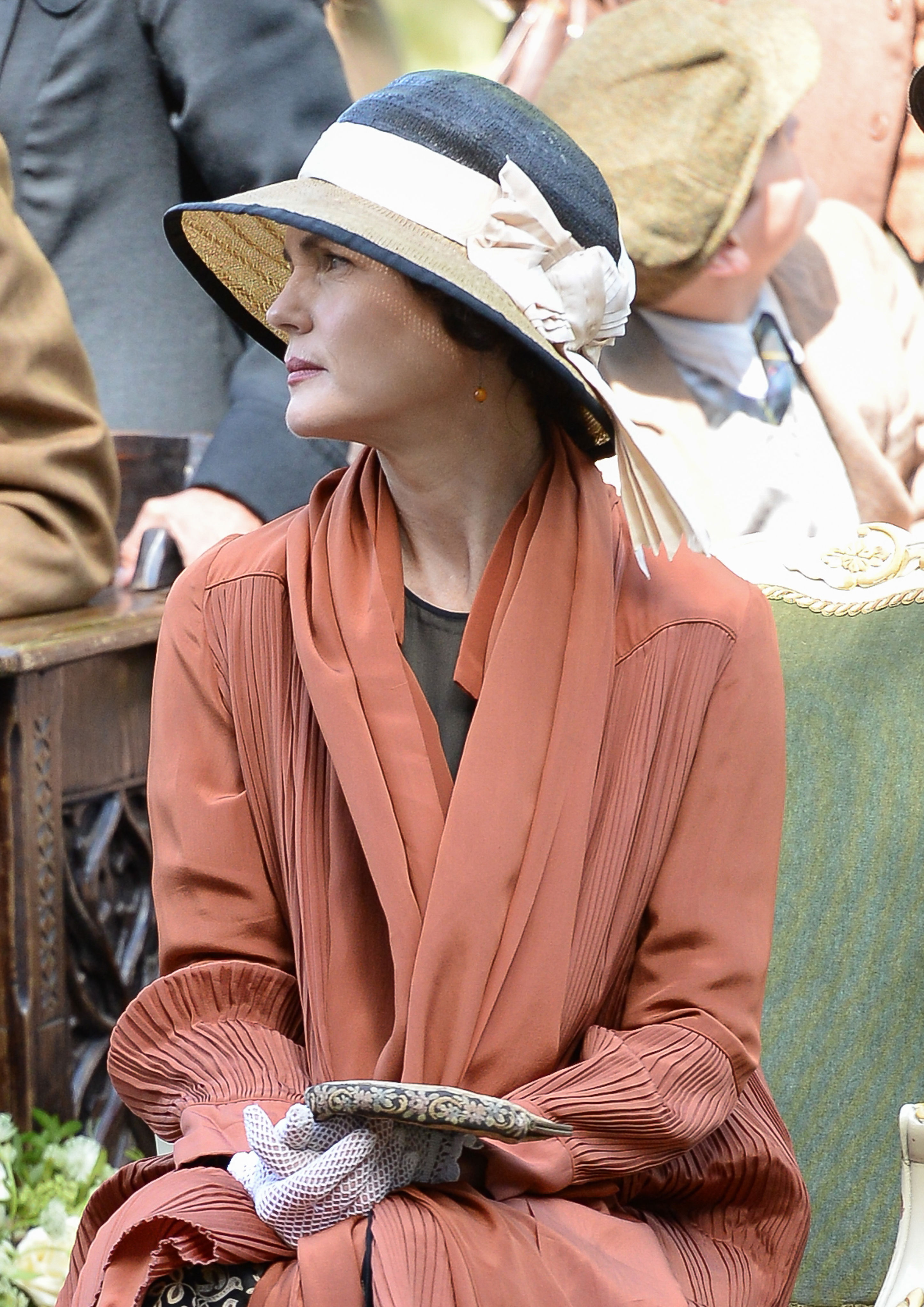 <p>Here's a close-up look at one of the hats and a gorgeous pleated coral day coat worn by Elizabeth McGovern (as Lady Cora) while filming the "Downton Abbey" series in Oxfordshire, England, in 2014.</p>