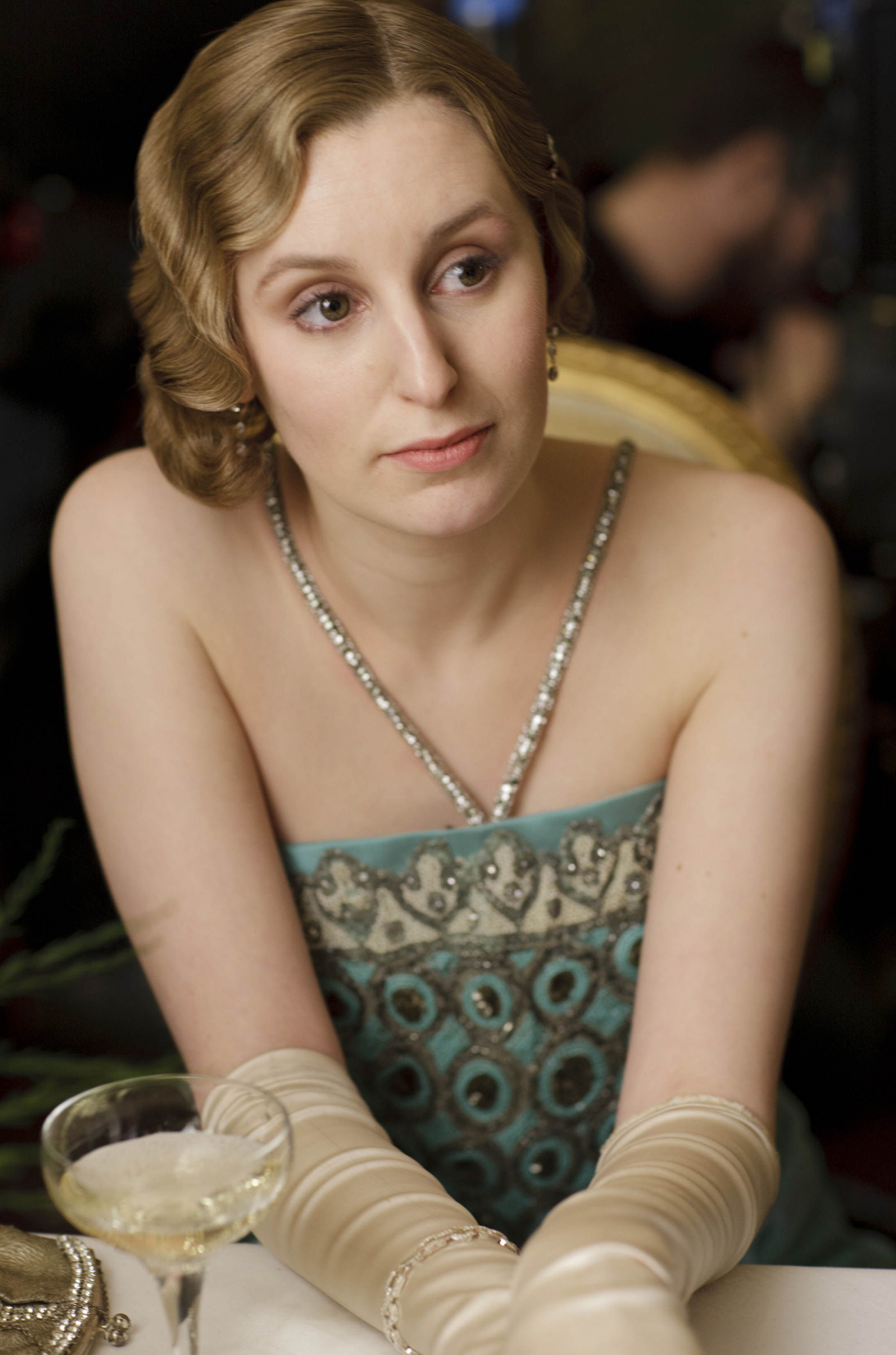 <p>Laura Carmichael, as Lady Edith, wore a striking blue, cream and metallic beaded halter-style dress with cream satin gloves on season 4 of "Downton Abbey."</p>