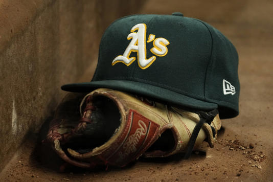 ARLINGTON, TEXAS - APRIL 21: A close up view of an Oakland Athletics hat and Rawlings glove during the game against the Texas Rangers at Globe Life Field on April 21, 2023 in Arlington, Texas. (Photo by Sam Hodde/Getty Images) Sam Hodde/Getty Images