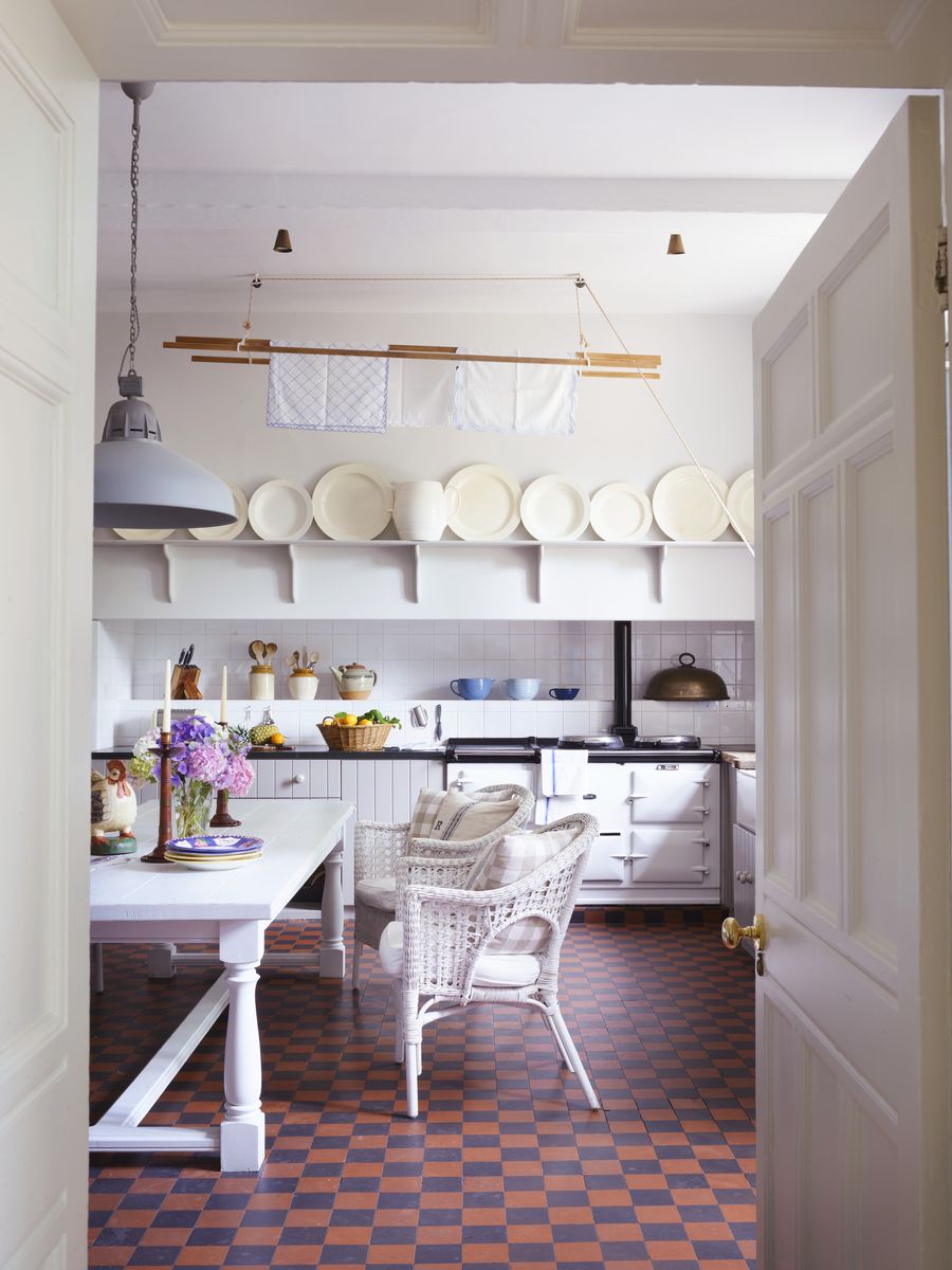 <p>A treasured collection of Wedgwood plates was hidden from the Nazis by Aeneas’s grandmother during World War II; resurrected, it now crowns kitchen shelving. The checkered floor tiles are Victorian.</p>