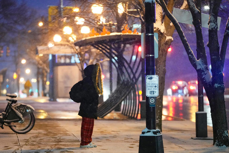 Pedestrians walk through the steady snowfall Friday night in downtown Columbus. The National Weather Service has upgraded Columbus and portions of central Ohio to a winter storm warning with up to 5-7 inches expected. Up to 8 inches are possible in isolated areas, the NWS says.