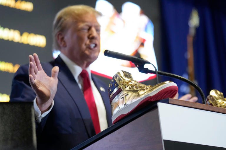 Donald Trump receives boos, cheers as he sells 399 gold sneakers at