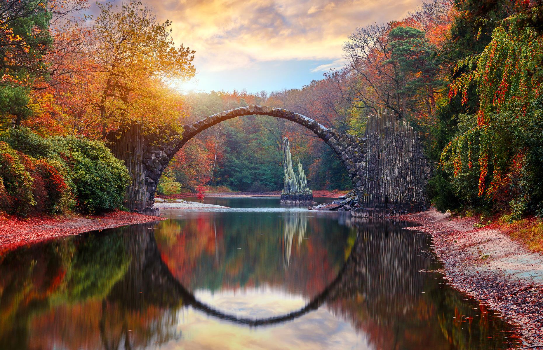 <p>Rakotzbrücke, in eastern Germany's Kromlauer Park, is one of several bridges in Europe to earn the moniker of the Devil's Bridge. The legend goes that the bridge, arching in a perfect semi-circle and reflecting in the still water below, is too perfect to have been made by human hands. It's said that Satan had a hand in its construction, claiming the soul of the first mortal to cross the structure in return. You can't cross the bridge but you can admire the devil's handiwork from afar.</p>