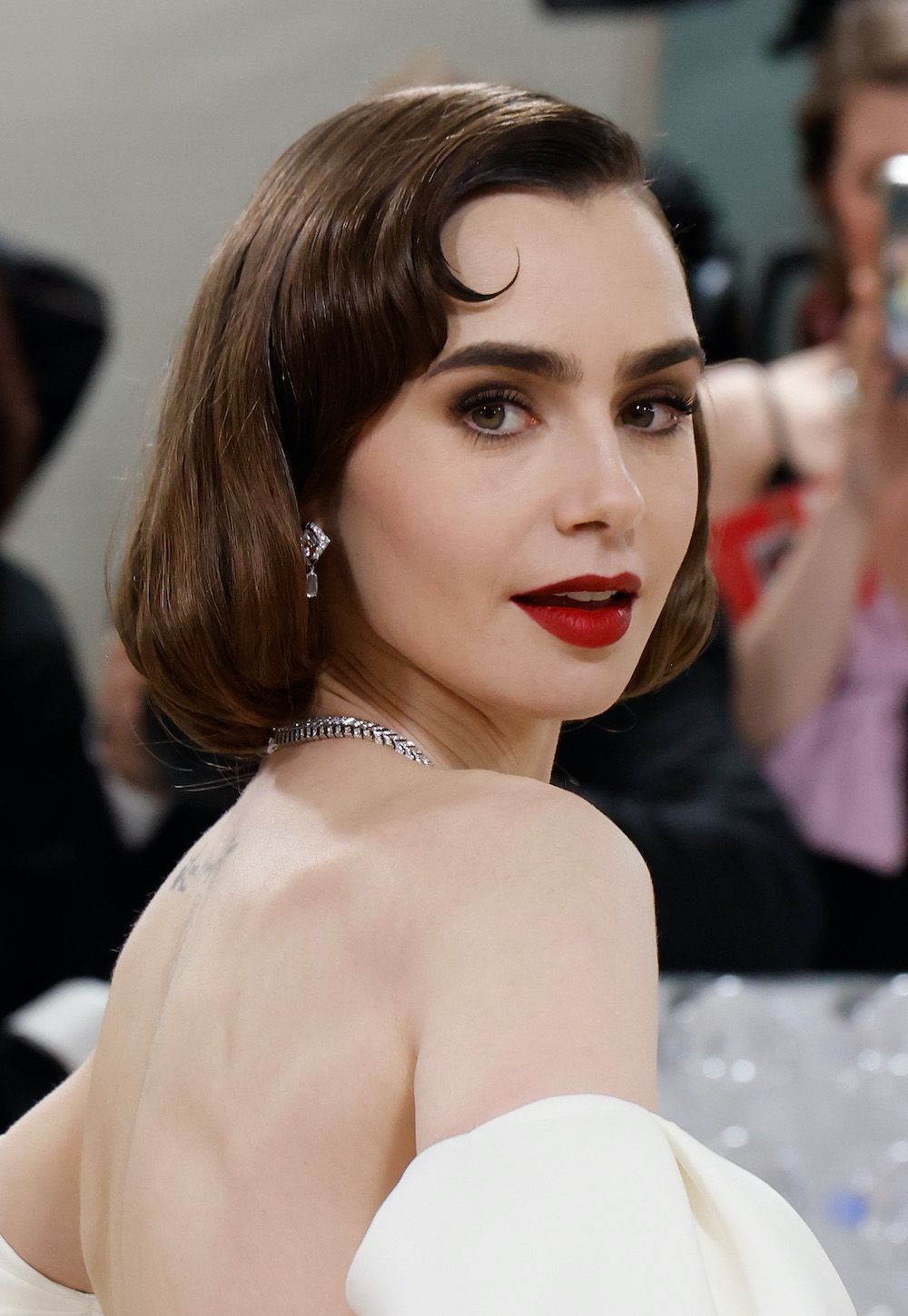 <p>                     Looking like she's stepped straight out of Old Hollywood with a vintage vibe to her overall look, Lily Collins opted for a classic red lip paired with a rich brown smokey eye for the 2023 Gala. A simple makeup look that injects a bit of glamour into any look.                   </p>
