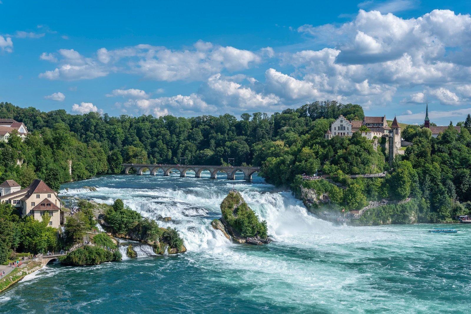 <p><span>Visit Rhine Falls near Schaffhausen, Switzerland, to witness one of Europe’s most powerful waterfalls. The falls are impressive for their size and the sheer volume of water cascading over a breadth of 150 meters. Boat trips take you up close to the falls, and several viewing platforms along the river provide different perspectives on this natural spectacle. The area around the falls is ideal for leisurely walks or picnics, making it a perfect day trip destination.</span></p> <p><b>Insider’s Tip: </b><span>Take a boat trip to the rock in the middle of the falls for an up-close experience. </span></p> <p><b>When To Travel: </b><span>Summer for boat trips and the best weather. </span></p> <p><b>How To Get There: </b><span>Drive or take a train to Schaffhausen, then a bus to the falls.</span></p>