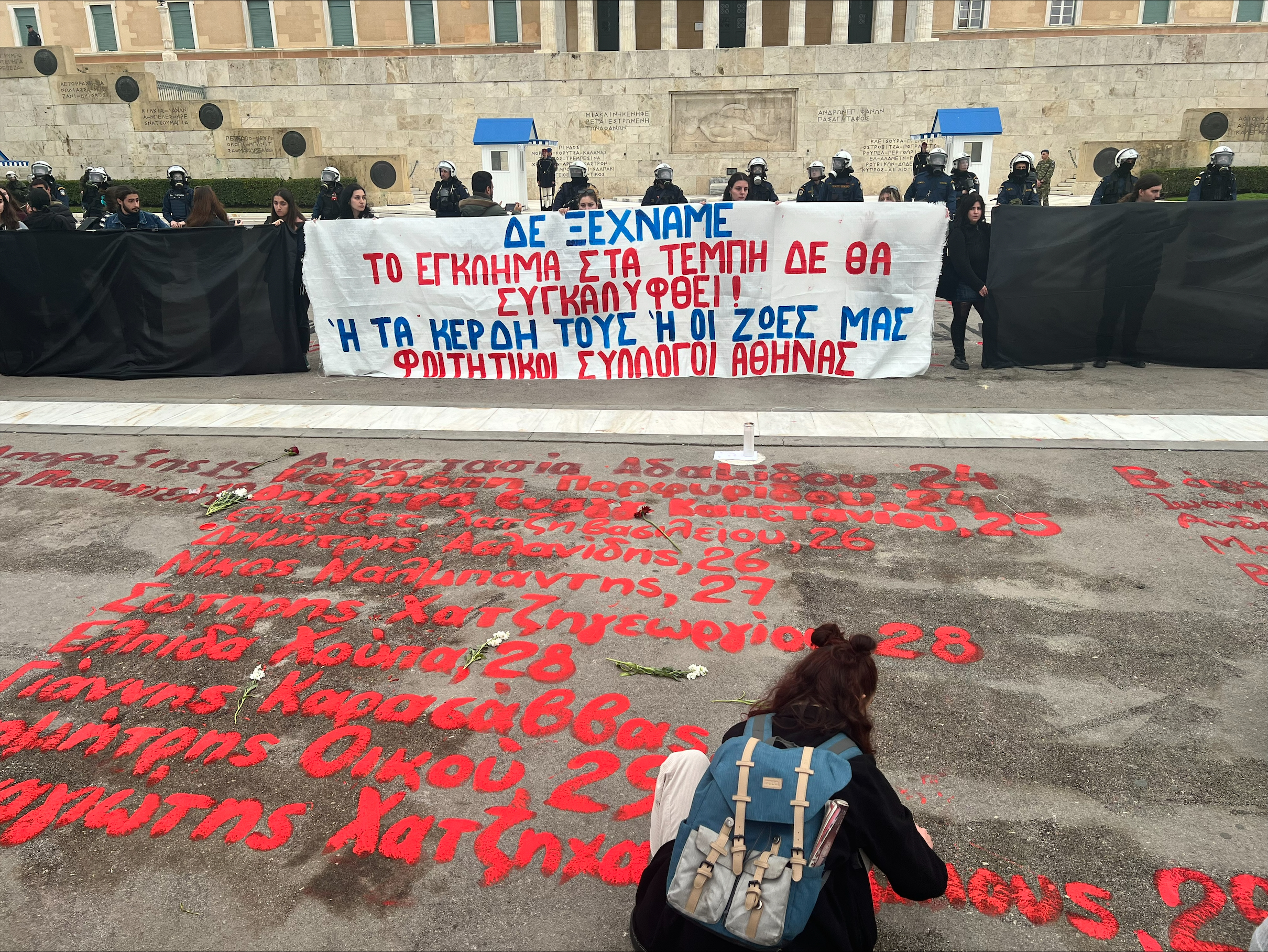 τέμπη: φοιτητές ξαναγράφουν τα ονόματα των 57 νεκρών που σβήστηκαν έξω από τη βουλή