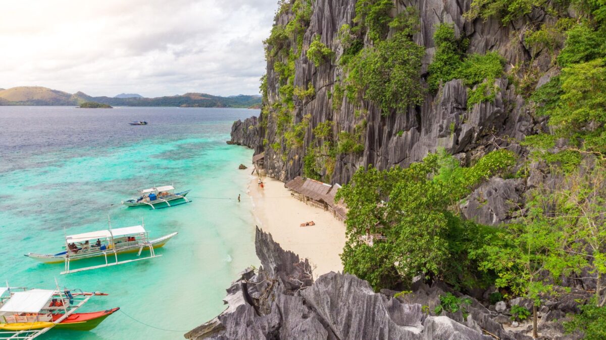 <p>Banol Beach in Coron, Palawan, is a slice of paradise with some of the softest, whitest sand you’ll ever see and waters in stunning shades of blue and teal that seem to come straight out of a painting. </p><p>Surrounded by impressive karst cliffs, this beach is perfect for those who love to pose, swim, kayak, or simply relax in a nipa hut by the shore. To reach this breathtaking beach, you can join a day trip from Coron or a private ferry for a more exclusive experience. </p>