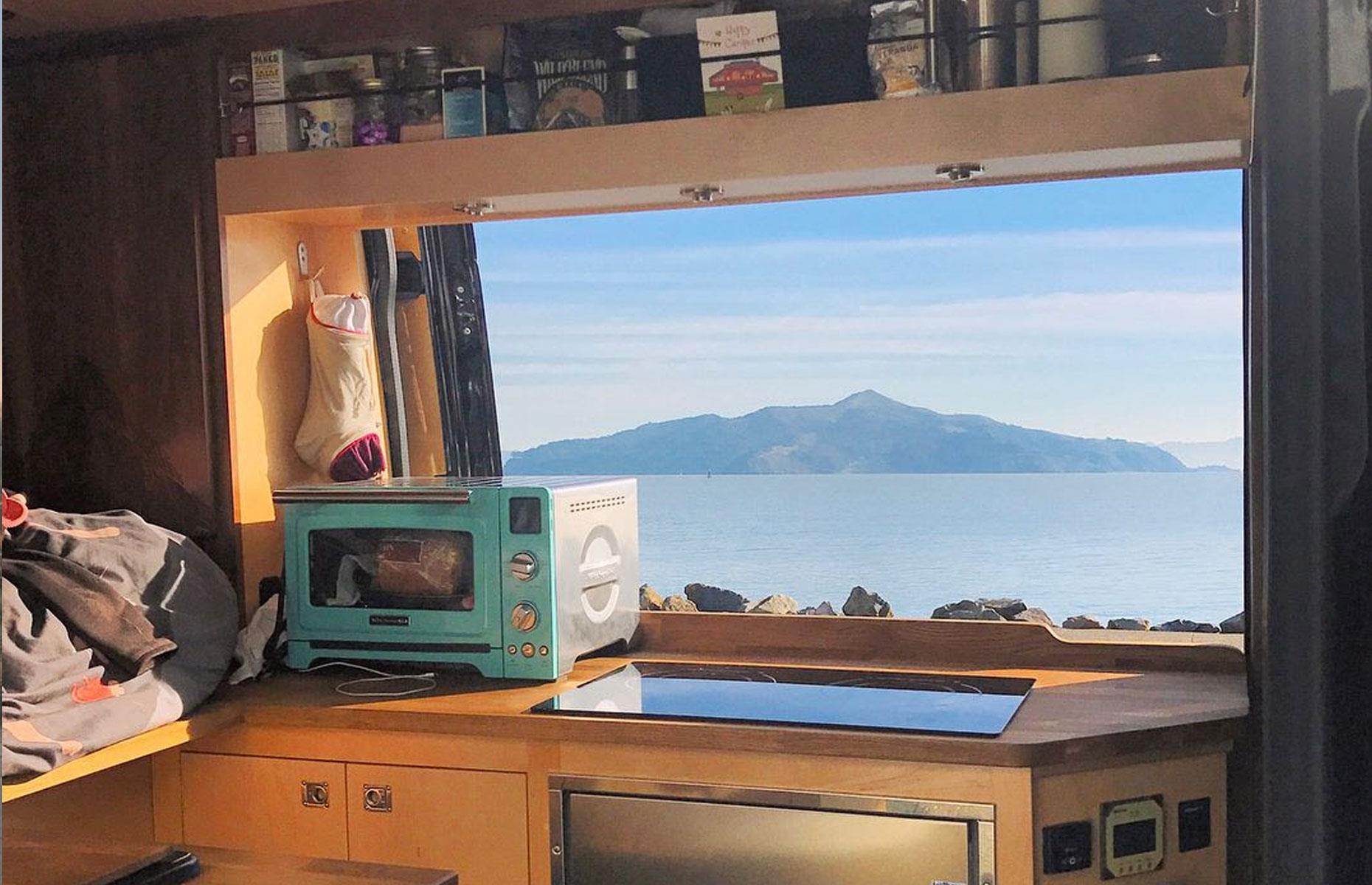 <p>Because it's their permanent home, Joe and Emilie have got all the essentials, plus a few luxuries. There's a full kitchen, with maple and walnut walls and cabinets for storage. Cooking with views like this would certainly make up for living in such close quarters. The campervan has also just been rejuvenated. "Now it looks as wonderful as the day we started back in 2016," says Joe. </p>