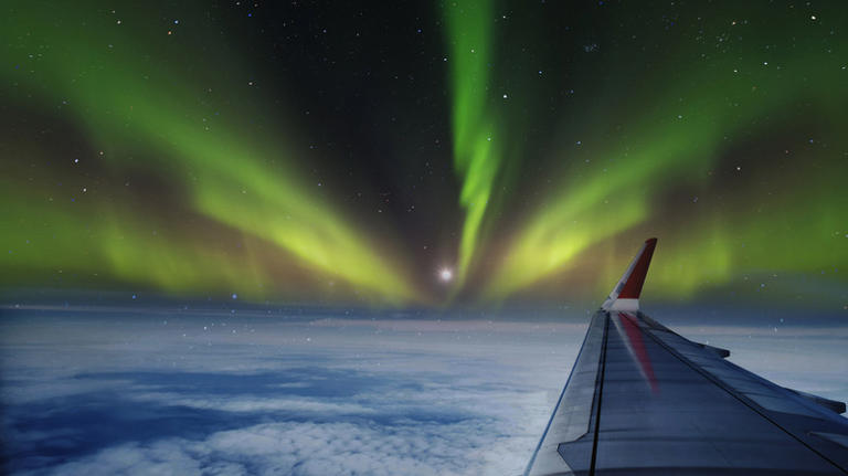 plane wing and northern lights