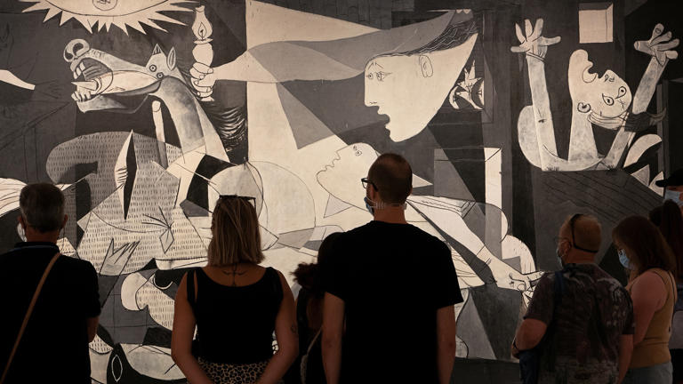 Viewers looking at Pablo Picasso's "Guernica" at the Reina Sofia Museum in Madrid