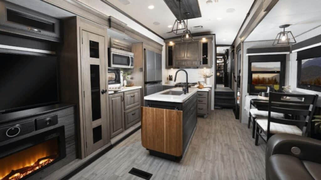 <p>The North Point 380RGKS boasts a whopping five slide-outs to really increase the square footage of the interior living space when you get to camp. Features like a walk-in closet and walk-in shower really make the master suite luxurious too.</p><p>But in the kitchen, they’ve recently added a 24″ x 24″ butcher block that flips up to create a countertop extension for meal prep. You’ll also love the reimagined wooden pull-out spice rack above the microwave.</p><p>Some of the other eye-catching features of this Jayco 5th wheel include an electric fireplace, a new 4K Smart TV, three-way adjustable headrests on the theater seats, and a built-in pop-up wireless charger in the dining area.</p>