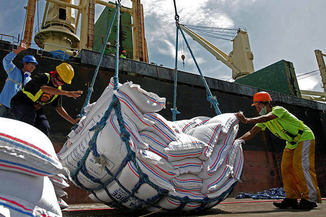 Workers unload part of the 890,000 sacks of NFA rice imported from Vietnam on Monday, August 18, at the Manila North Harbor in Tondo, Manila. The shipment is expected to provide the rice needs of Metro Manila for the months of August and September.