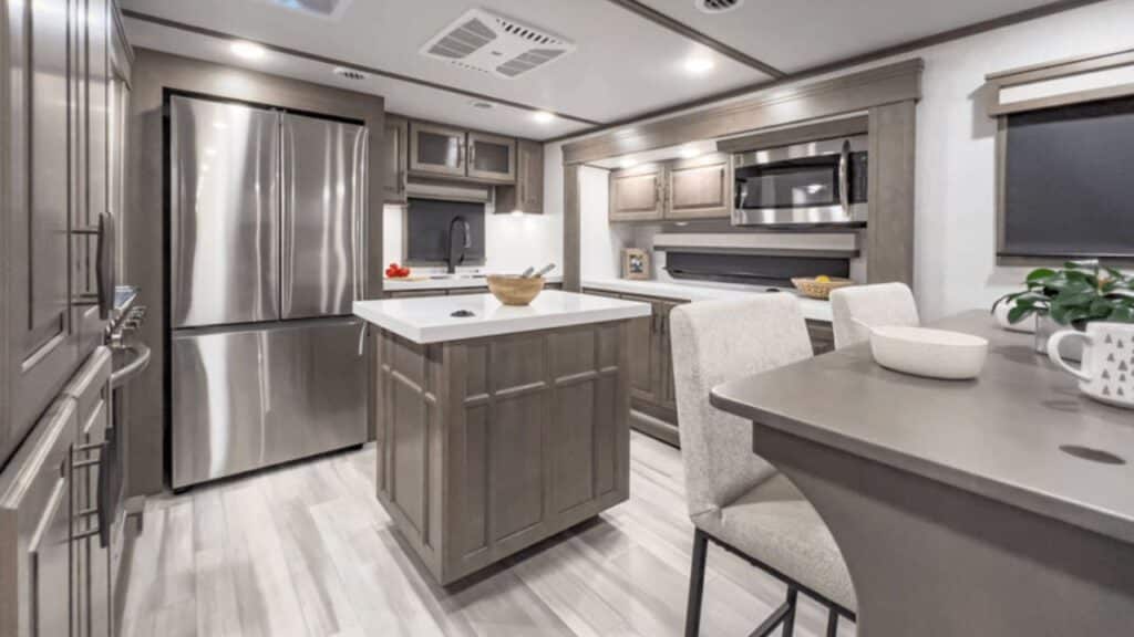 <p>The Grand Design Solitude might be the last RV on our list, but it’s certainly not the least. It’s an incredibly spacious floor plan with five slide-outs, a pull-out outdoor kitchen, and a super spacious rear kitchen.</p><p>The rear kitchen island is one of the biggest we’ve seen and the kitchen is prepped with a dishwasher to make cleaning up after large family gatherings so much easier. The 24-inch residential oven in the kitchen also gives you baking options you won’t get with most other RVs.</p><p>Two tri-fold sofas in the living room provide plenty of extra sleeping space if you need it. But if you work remotely from your RV, you can substitute a desk for one of the sofas to give you a dedicated work zone to be productive between your outdoor adventures.</p>