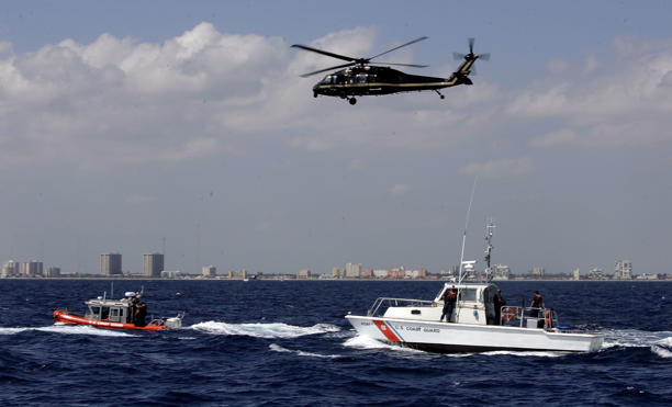 US Coast Guard boats and a US Customs and Border Protection helicopter participate in a mass migration drill off the coast of Miami, Florida.