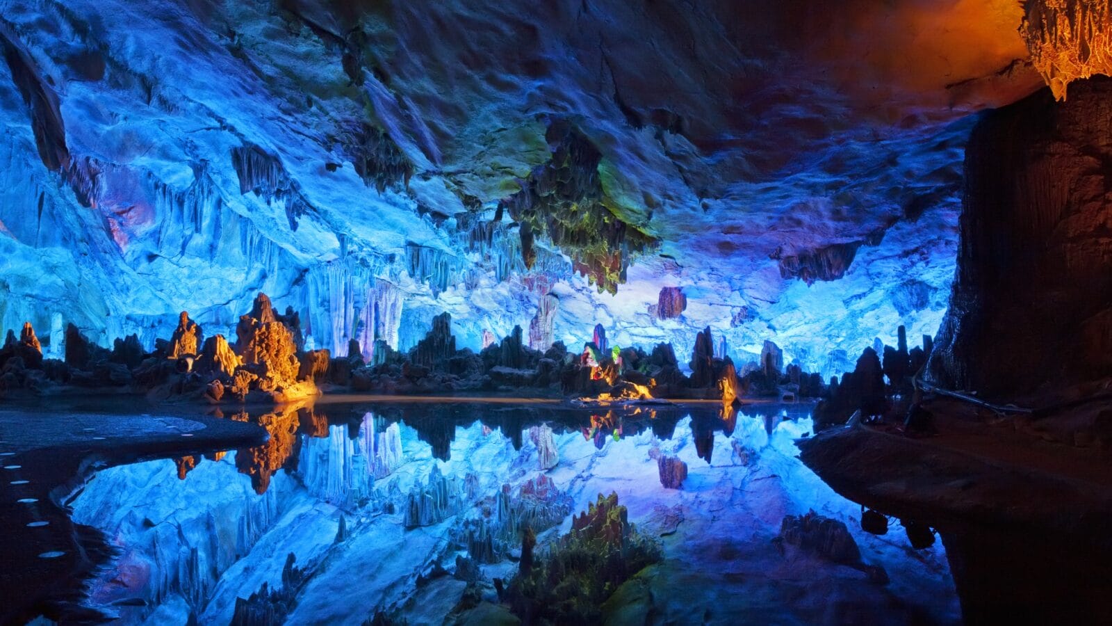 <p>Also known as the Palace of the Natural Arts, China’s Reed Flute Cave is named after the reeds growing outside the cave. Inside the cave, walls of limestone formations are decorated by ancient inscriptions dating to the 8<sup>th</sup> century BCE.</p><p>The well-maintained cave is a pleasure to walk through and has magical vibes thanks to its multicolored lighting.</p>