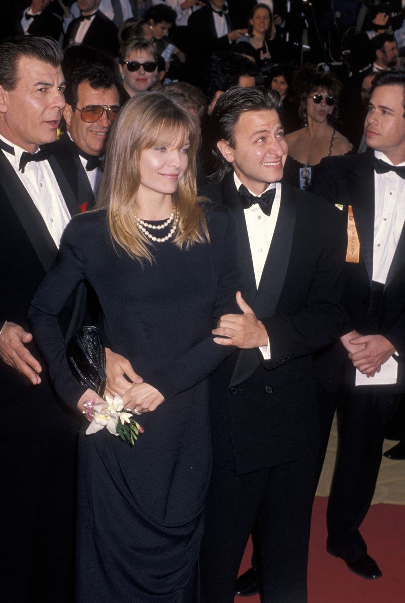 <p>She donned another knockout gown at the 1990 Academy Awards. Her look consisted of a long-sleeve black dress, a layered pearl necklace, and a ruched metal-accented clutch.</p>