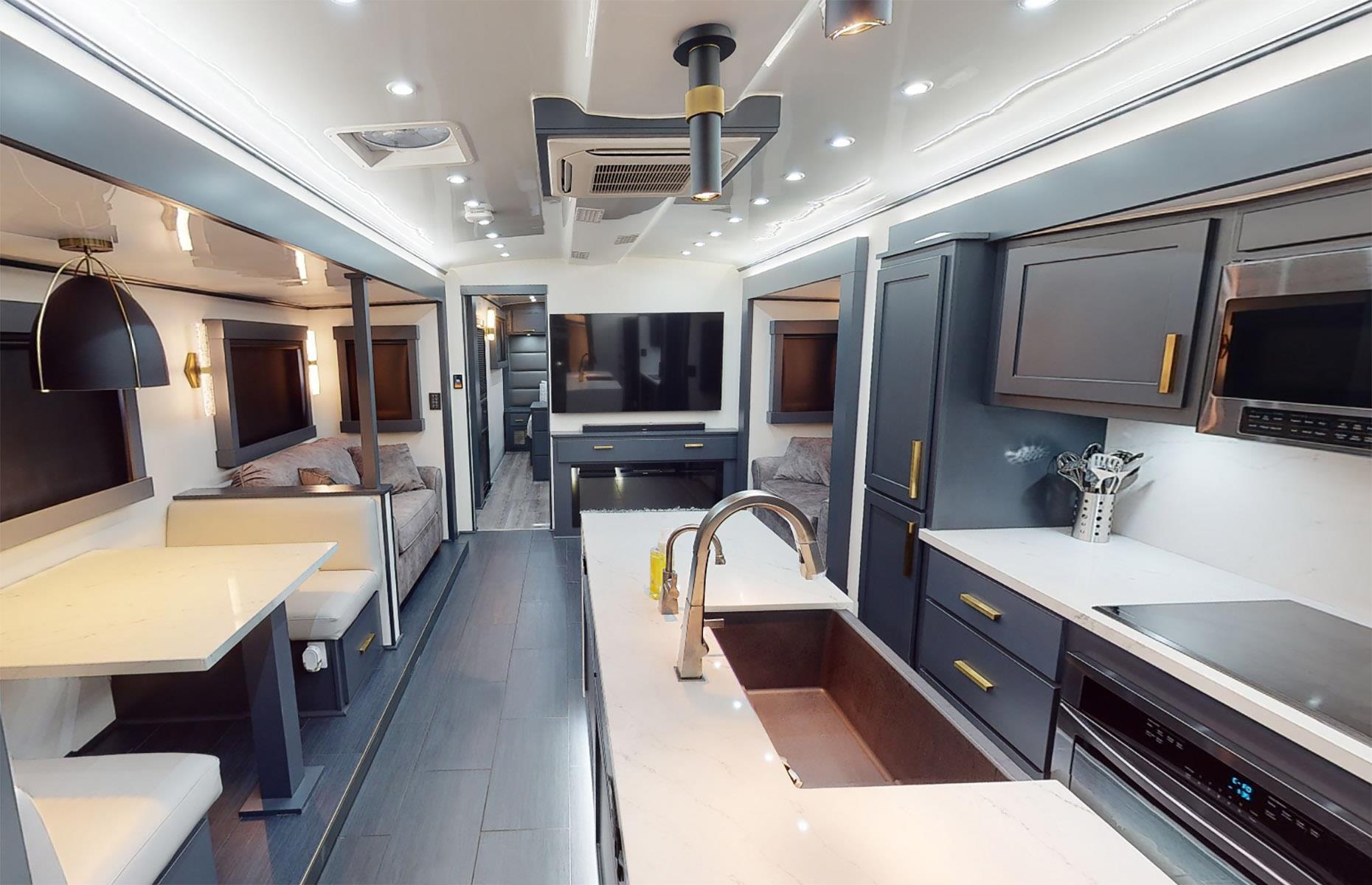 <p>As you can see in this custom design, the décor is simple and elegant, with a smart, traditional feel. Space is cleverly used and quality fixtures and fittings add to the high-spec finish. The living area flows well and is a cut above the sort of interior you'd expect to find in an RV. </p>  <p>In this particular model, the sleek kitchen features beautiful dark cabinetry with gold-hued hardware and even a stunning marble-topped preparation island. </p>