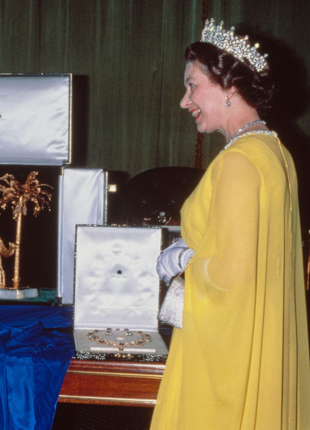 <p>                     Yellow isn't a colour we often saw the late Queen wearing during the middle of her reign, however after seeing this picture of her here with the Girls of Great Britain and Ireland tiara, we can't understand why. She wore this ensemble whilst exchanging gifts with the Emir of Dubai, Sheikh Rashid bin Saeed Al Maktoum at the Jumeirah Palace in Dubai, United Arab Emirates in 1979.                   </p>