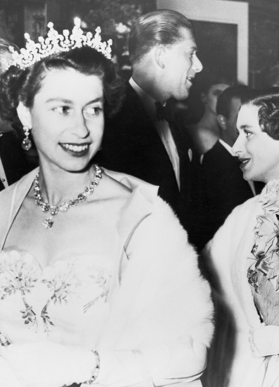<p>                     Perhaps not the most relatable theatre attire, but what else would you expect from the Queen of England? Here she is pictured smiling to the crowds along with her sister, Princess Margaret. The diamond tiara was paired with large jewelled earrings and a matching necklace.                   </p>