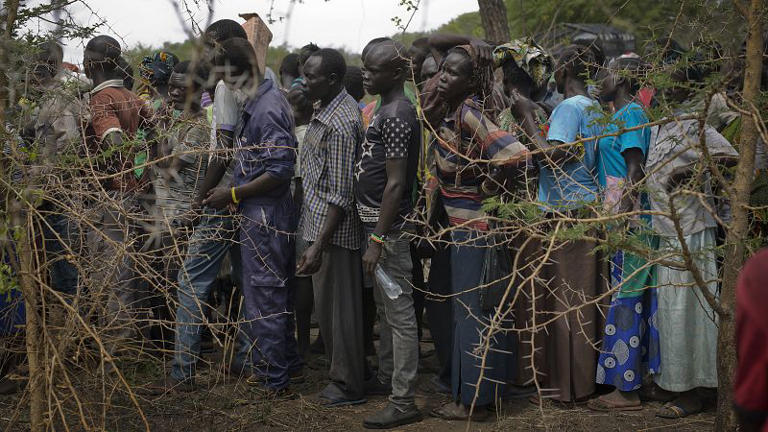 Des réfugiés sud-soudanais font la queue dans la brousse à un point de distribution de fournitures au camp d'Imvepi, dans le nord de l'Ouganda, 4 avril 2017.