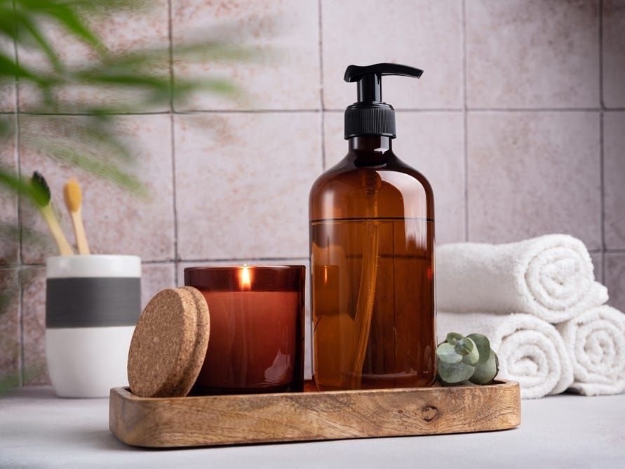 <p>If you don't want to just put all of your personal items like shampoo, body wash, or dishwashing soap completely away, putting them into neutral-colored glass bottles can create a more aesthetically pleasing look. </p><p>"Only keep out on the counter things that are generally pretty and maybe of the same color or the same ilk," Baer said.</p>