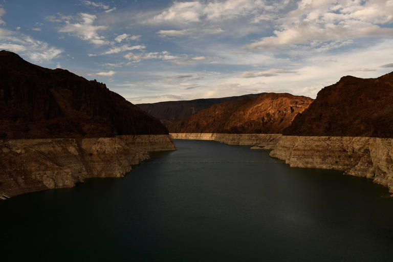 A "bathtub ring" is visible at sunset during low water levels the Lake Mead reservoir due to the western drought on July 19, 2021 as seen from the Hoover Dam on the Colorado River at the Nevada and Arizona state border. Lake Mead's water levels have since started to improve, and a recent snowstorm in Colorado could help the lake's water outlook this spring.