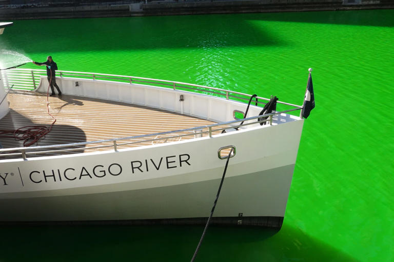A worker cleans a boat in the Chicago River after it was dyed green in celebration of St. Patrick's Day on March 13, 2021.