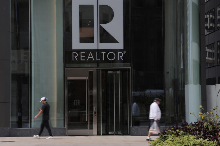 People walk past the National Association of Realtors building at 430 N. Michigan Ave. in Chicago on Sept. 20, 2023.