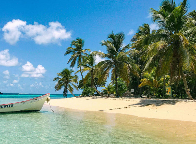 A boat brings beachgoers between Paradise Beach and Sandy Island in Grenada.