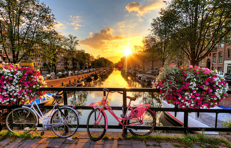 best-solo-trip-locations-beautiful-sunset-in-amsterdam-with-bicycles-and-blooming-flowers-main