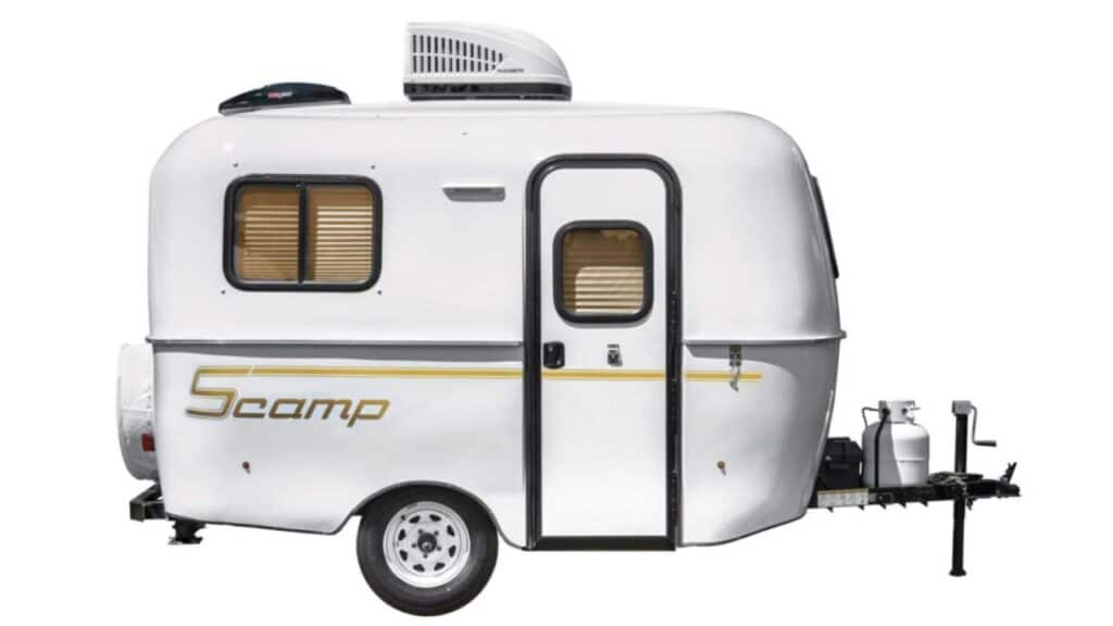 <p>If you want a small trailer with toilet and shower you can stow away in the garage when you’re not adventuring, the Scamp Deluxe is perfect.</p><p>There are three floorplans. Layout B features a wet bath, while there’s no toilet in the other two. Layout B includes 2 closets, a kitchenette with sink and a stove, a wet bath, and a dinette that turns into a bed. It’s small, simple, yet very practical. </p><p>The interior is cozy yet modern; while the exterior has a vintage feel that makes it super cute. Scamp Trailers managed to squeeze a lot into this small space. On the front hitch, there’s space to store 2 gas bottles, so they’re safely outdoors and don’t take up any extra room.</p><p>The 13′ Scamp Deluxe weighs <a href="https://www.thewaywardhome.com/ultra-lightweight-travel-trailers-under-2000-pounds/">less than 2,000 pounds, </a>so you can tow it with almost any car and it’s very fuel-efficient. </p>