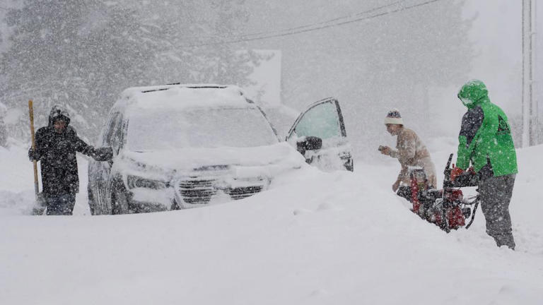 Residents try to clear snow around a car in Truckee on Saturday. - Brooke Hess-Homeier/AP