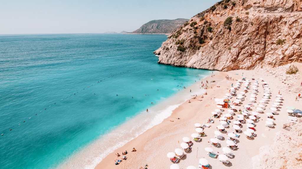 <p>Looking for the perfect Mediterranean vacation that does not include Italy or Greece? You should try out Kaputas Beach in Turkey. The small sandy cove and massive cliffs on the side are unbelievably beautiful. You can take a staircase from the mountain parking lot to access the beach. </p><p>The view from the top is captivating. Sitting on the cliffs and watching over the beach is a good enough activity done by many tourists, which tells you how magnificent the shore is.</p><p class="has-text-align-center has-medium-font-size">Read also: <a href="https://worldwildschooling.com/european-beach-towns/">Scenic Beach Towns in Europe</a></p>