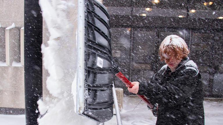 Arlo Connery-Dwyer shovels the Western Manitoba Centennial Auditorium entrance in Brandon Sunday. Parts of Manitoba are being hit with with heavy snow or blowing snow.