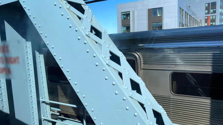 A Megabus passes by a regional train on Philadelphia’s Ben Franklin Bridge. -lead