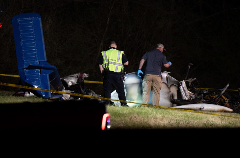 Crash investigators study the wreckage of a small plane crash just west of mile marker 202 on I-40 in Nashville, Tenn., Monday, March 4, 2024. Fatalities were reported, but officials declined to say how many were killed in the crash which hit a grassy area south of the shoulder of the interstate.